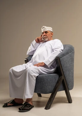 رجل عماني مسن يجلس في حالة تفكير عميق