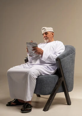 رجل عُماني مسن يكتب على جهاز لوحي في الاستوديو