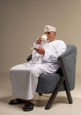 Senior Omani Man Drinking Coffee in Traditional Dress