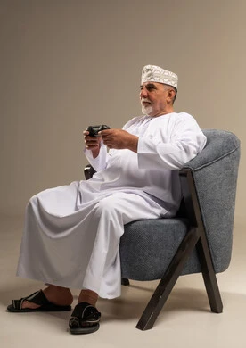 Elderly Omani Man Playing Video Games in Studio