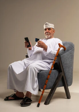 Elderly Omani Man Using Smartphone and Credit Card