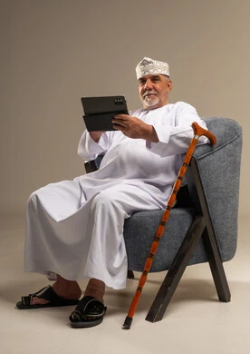 Elderly Omani Man Using Tablet with Traditional Clothing