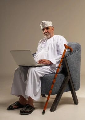 رجل عماني مسن يستخدم اللابتوب في الاستوديو