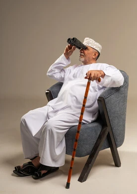 رجل عُماني مسن ينظر من خلال المنظار