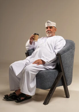 Senior Omani Man Sitting with Coffee in Studio