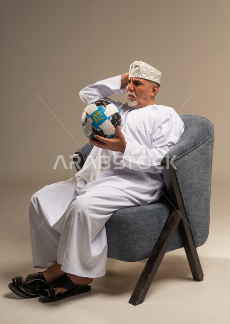 Elderly Omani Man with Soccer Ball in Studio