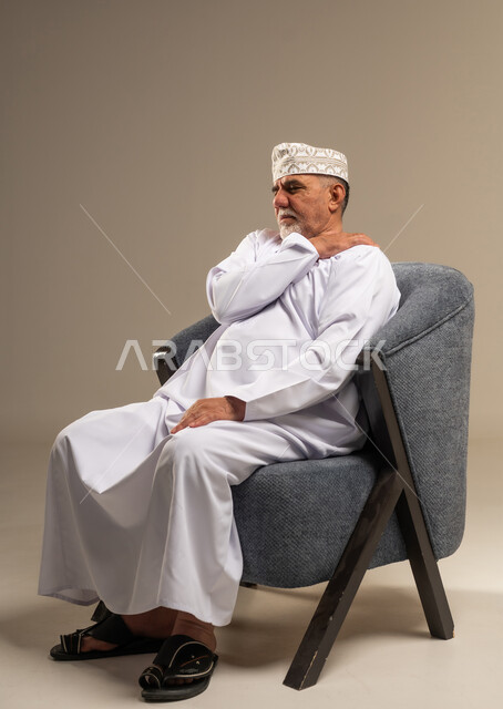 رجل عُماني مسن يعاني من ألم في الكتف داخل استوديو