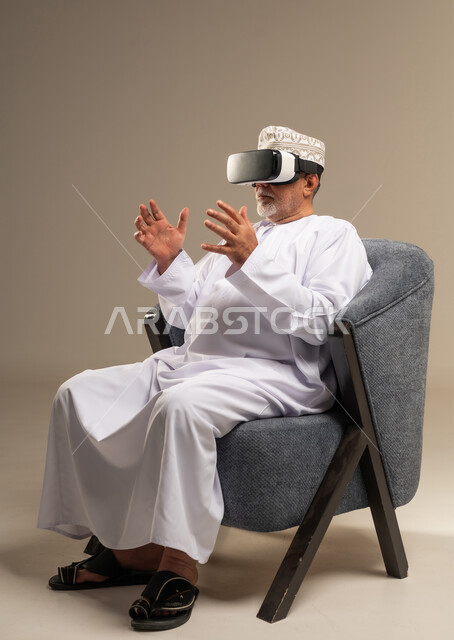 Omani Senior Man Using VR Headset in Traditional Dress