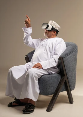 رجل عماني بالزي التقليدي يستخدم نظارة الواقع الافتراضي