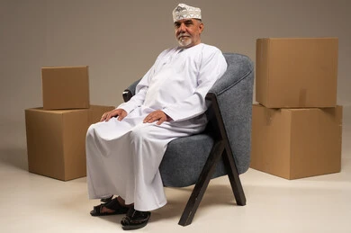 Elderly Omani Man Sitting with Cardboard Boxes
