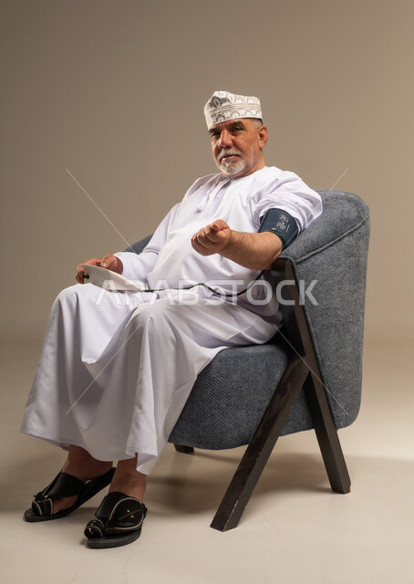 رجل عماني مسن يقيس ضغط الدم في الاستوديو