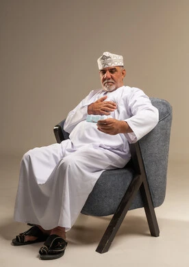 رجل عُماني مسن يمسك بالدواء في الاستوديو