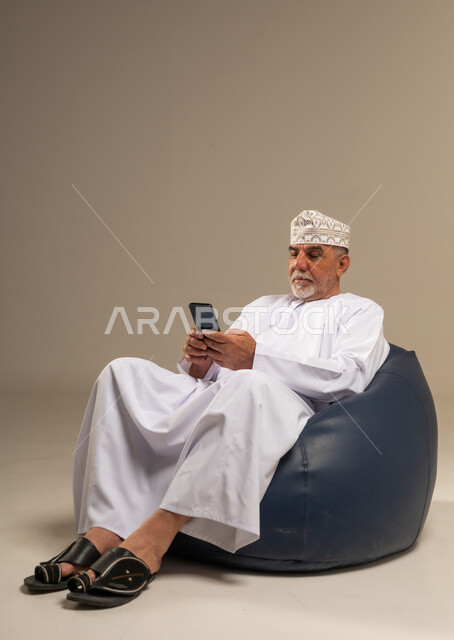 Omani Senior Man Using Smartphone in Studio