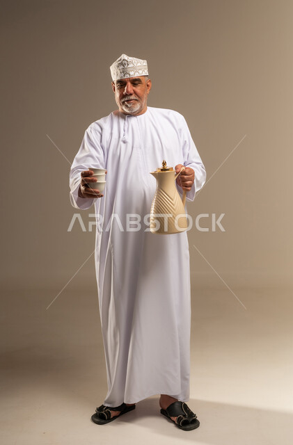 Omani Man in Traditional Dishdasha Holding Coffee Thermos
