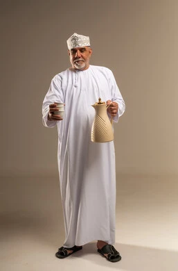 رجل عماني بالزي التقليدي يحمل دلة القهوة العربية