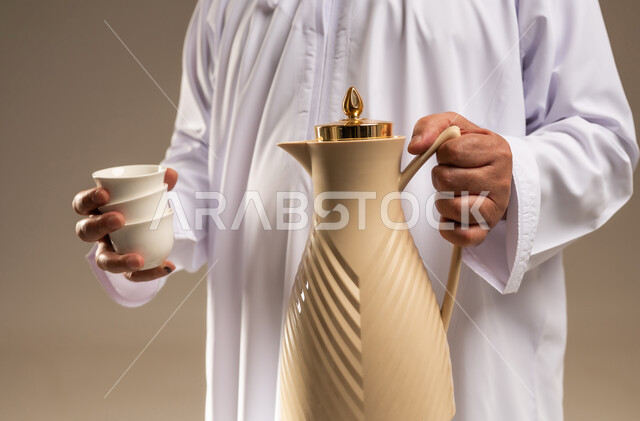Arab Man in Thobe Holding Arabic Coffee Thermos