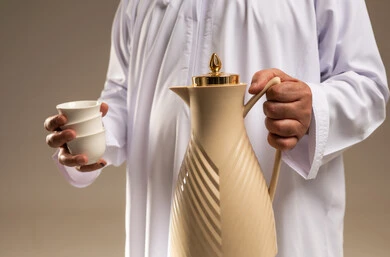 Arab Man in Thobe Holding Arabic Coffee Thermos