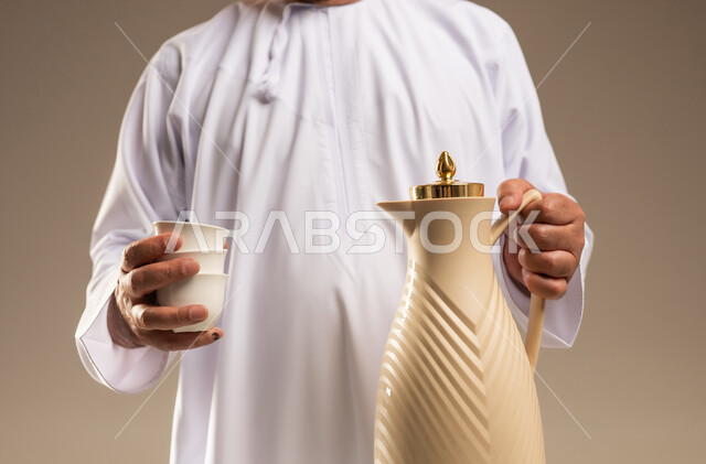 Arab Man in White Kandura Holding Coffee Dallah