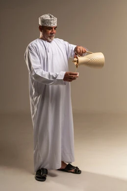 رجل عماني يصب القهوة العربية التقليدية في الاستوديو