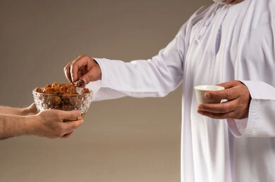 رجل سعودي يتناول التمر مع القهوة العربية