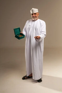 رجل عماني بالزي التقليدي يحمل اللبان العماني