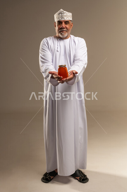 Senior Omani Man Holding Honey Jar in Studio