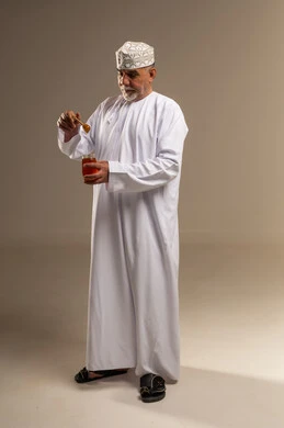 Senior Omani Man Holding Honey Jar in Studio