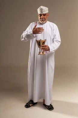 رجل عُماني يمسك بمبخرة بخور تقليدية بالزي الوطني