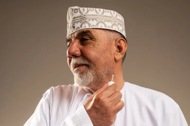 رجل عماني مسن يضع دهن العود التقليدي