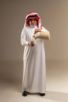 رجل سعودي يسكب القهوة العربية التقليدية في استوديو