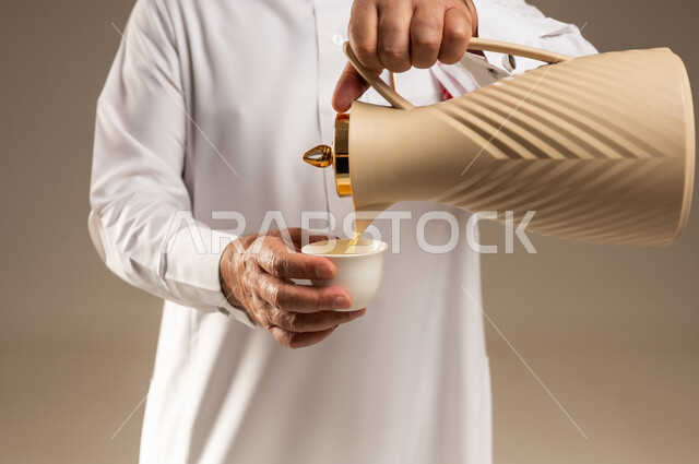 رجل سعودي يصب القهوة العربية من الدلة