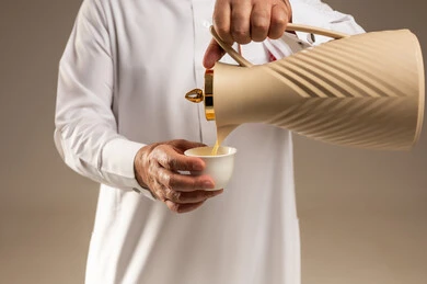 رجل سعودي يصب القهوة العربية من الدلة