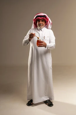 Elderly Saudi Man Holding Natural Honey Jar in Studio