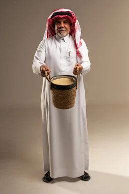 رجل سعودي مسن يحمل سلة خوص تقليدية