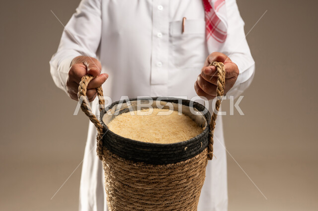 رجل سعودي يحمل سلة أرز خوص تقليدية