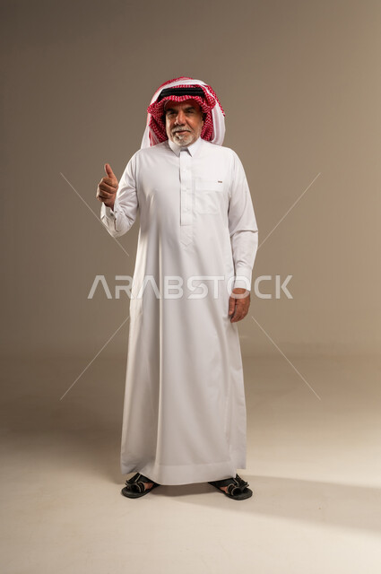 رجل سعودي بالزي التقليدي يشير بعلامة الإعجاب