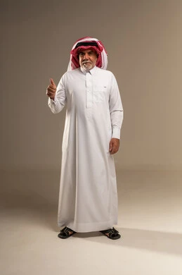 رجل سعودي بالزي التقليدي يشير بعلامة الإعجاب