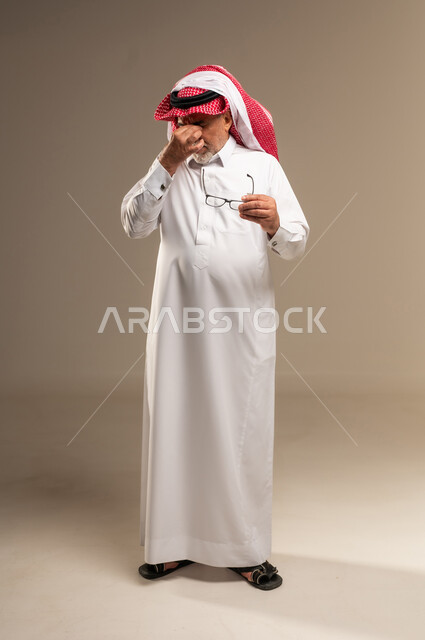 Tired Senior Saudi Man Rubbing Eyes in Studio