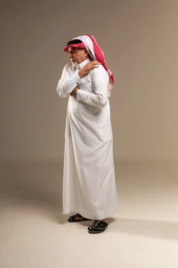 Elderly Saudi Man Holding Shoulder in Pain