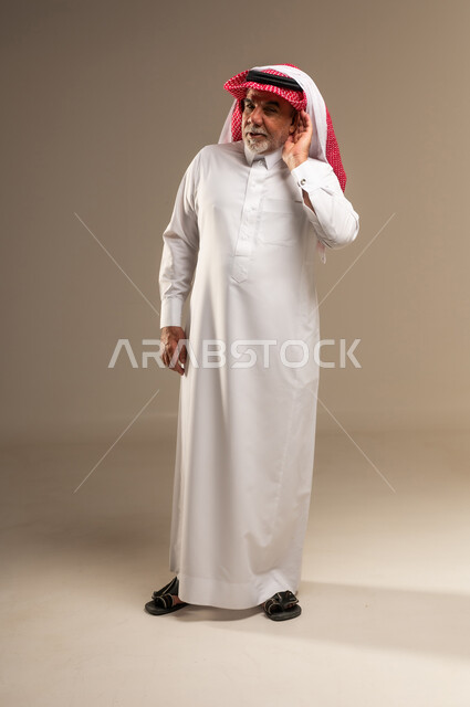 رجل سعودي مسن بالزي التقليدي في وضعية الاستماع