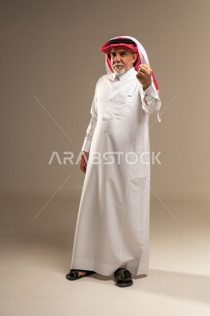 Senior Saudi Man in Traditional Thobe Making Hand Gesture