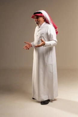 رجل سعودي مسن بتعبيرات وجه متفاجئة بالزي التقليدي