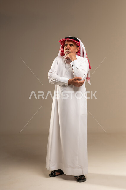 رجل سعودي مسن بوضعية تفكير بالزي التقليدي