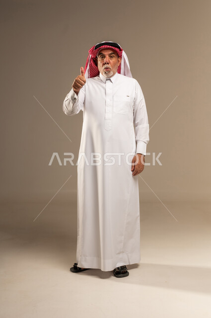رجل سعودي مسن يقدم إشارة الإعجاب في الاستوديو