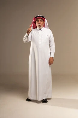 رجل سعودي مسن يقدم إشارة الإعجاب في الاستوديو