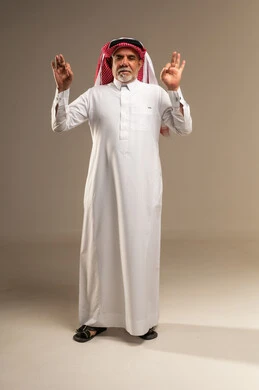 رجل سعودي مسن يؤدي إيماءة التمام في الاستوديو