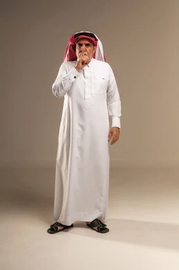 Elderly Saudi Man Making Shushing Gesture in Studio