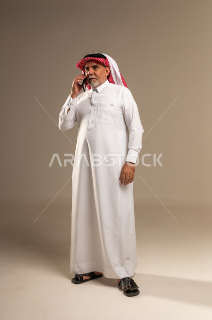 رجل سعودي مسن يتحدث عبر الهاتف في الاستوديو
