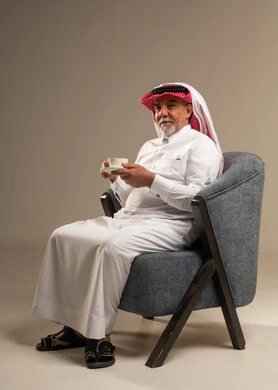 رجل سعودي مسن بالزي التقليدي يحمل فنجان قهوة