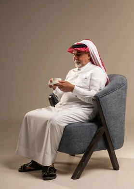 رجل سعودي مسن يشرب القهوة بالزي التقليدي